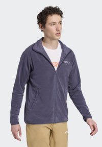 Fleece jacket in dark blue with a zip front. Features two side pockets and a high collar. Displays "TERREX" logo on the chest.