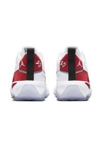 Un paio di sneaker da basket bianche e rosse viste da dietro, caratterizzate da fasce nere sul tallone, loghi Jumpman e il numero 23 su ciascun tallone.