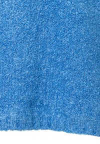 Fluffiger blauer Stoff mit einer strukturierten Oberfläche, die einen weichen, unregelmäßigen Flor aufweist; die Kanten haben ein gestricktes Finish.