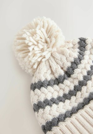 Strik beanie med et cremefarvet og gråt stribet design, der har en fluffy creme pom-pom på toppen. Fremstillet af tykt, tekstureret garn.