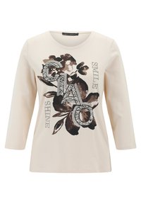 Crèmefarbiges Langarmshirt mit Rundhalsausschnitt, das ein florales Design in Braun und Schwarz aufweist und das Wort "CIAO" mit Strasssteinen verziert ist.