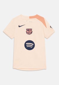 Pfirsichfarbenes kurzärmeliges Trikot aus leichtem Stoff, mit einem navyfarbenen Barcelona-Emblem und Spotify-Logo auf der Vorderseite, ergänzt durch kontrastierende Akzente.