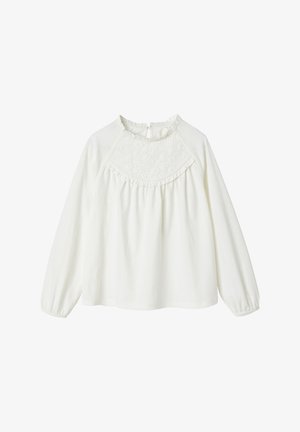 Long-sleeve white blouse in lightweight fabric, featuring a textured yoke, ruffle details along the neckline, and a back keyhole closure.