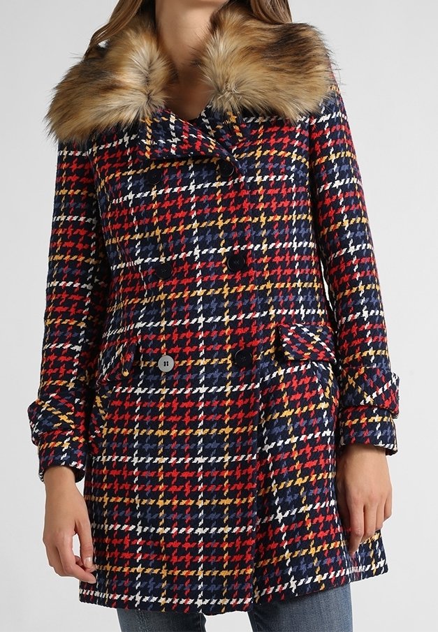 Dvouřadový kabát z vlněné směsi s červeným, modrým, žlutým a bílým houndstooth vzorem, s odnímatelným límcem z umělé kožešiny.