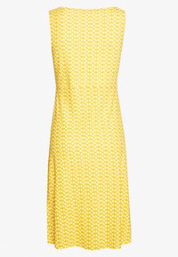 Keltainen hihaton mekko, jossa on sovitettu yläosa ja levenevä hame, koristeltuna valkoisella pilkkuprintillä. Pehmeä kankaan texture.