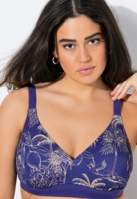 Sostegno in pizzo viola con un motivo floreale e tropicale in beige. Presenta un design a scollo a V e spalline regolabili per un comfort ottimale.