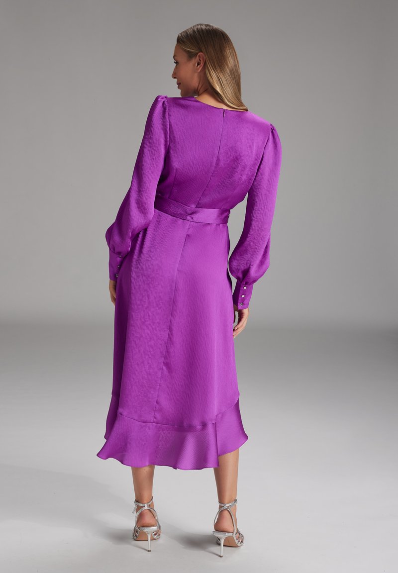 Fioletowa sukienka midi z długimi, bufiastymi rękawami, podkreśloną talią, teksturowanym materiałem i falbanką u dołu; posiada zamek z tyłu oraz akcenty z guzikami.