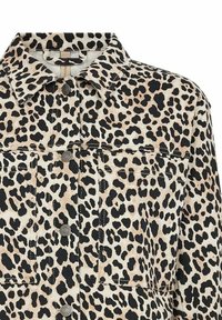 Spotty denimjacka i leopardmönster som har svarta och beige färger, krage, knappad front och två bröstfickor med en texturerad yta.