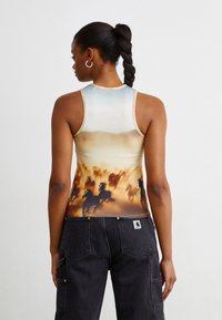 Fitted sleeveless top in a gradient of blue to warm beige, featuring a graphic of galloping horses and a smooth texture.