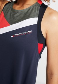 Ärmlös atletisk tanktop i marinblått, med färgblock i röd, vit och grön. Tillverkad av textil, lätt material med logotryck.