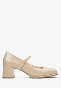 Beżowe lakierowane buty Mary Jane z kwadratowym noskiem, szerokim słupkowym obcasem i wąskim paskiem na kostce z klamrą.