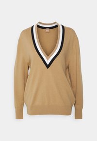 Pull marron camel avec un col en V profond orné de rayures noires et blanches, manches longues, et poignets et bordures côtelés.