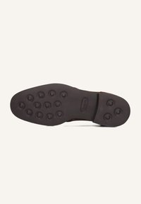 Semelle en cuir brun avec une surface texturée, présentant des motifs de grip circulaires et le nom de la marque 'Greve' en relief.