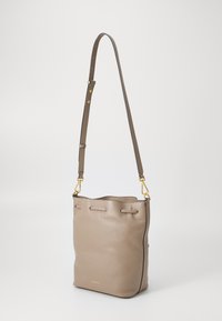 Borsa a secchiello in pelle taupe chiaro con finitura testurizzata. Tracolla regolabile e dettagli in metallo dorato. Apertura superiore con chiusura a coulisse.