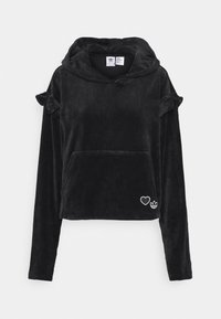 Svart, sammetslen hoodie med långa ärmar, volangdetaljer på axlarna, stor framficka och vit broderad hjärta och logga vid fållen.