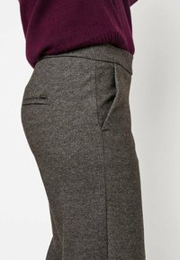 Gray, textured fabric trousers with a tailored fit, featuring a side pocket and subtle hardware accent near the waistband.