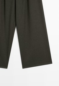 Pantaloni a gamba larga verde scuro realizzati in un tessuto morbido e testurizzato. Presentano un design pulito e sartoriale con vita alta e senza elementi di fissaggio visibili.