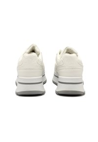 Coppia di sneakers bianche viste da dietro, con suole texturizzate e sottili motivi in rilievo nell'area del tallone.