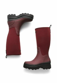 Vinröda gummistövlar med en strukturerad yta, hög skaft, svart sula och mönstrad yttersula. Har en dragrem för enkel påtagning.