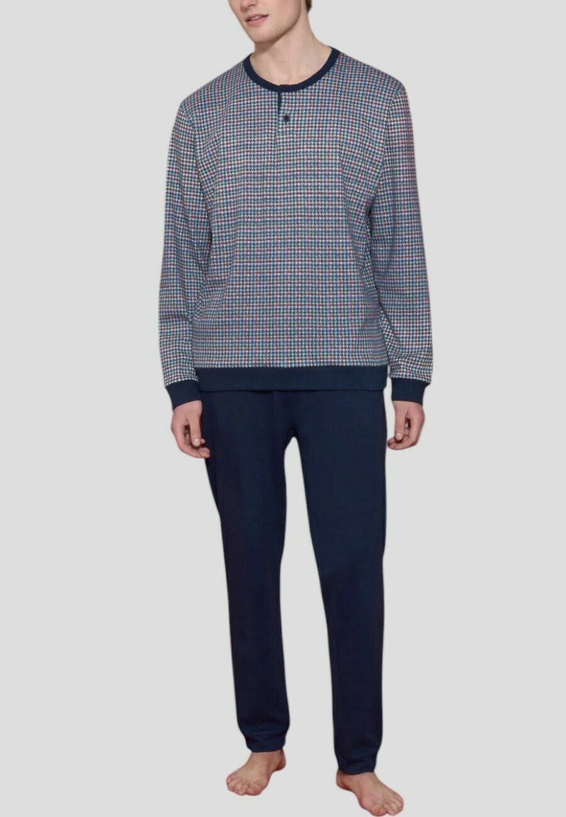 Top a maniche lunghe a scacchi in rosso, blu e bianco, abbinato a pantaloni blu navy. Il top presenta un collo tondo e polsini a coste.