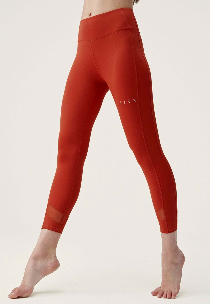 Röda högmidjade leggings gjorda av stretchigt tyg med mesh-paneler vid anklarna och en liten logotypdetalj på låret.