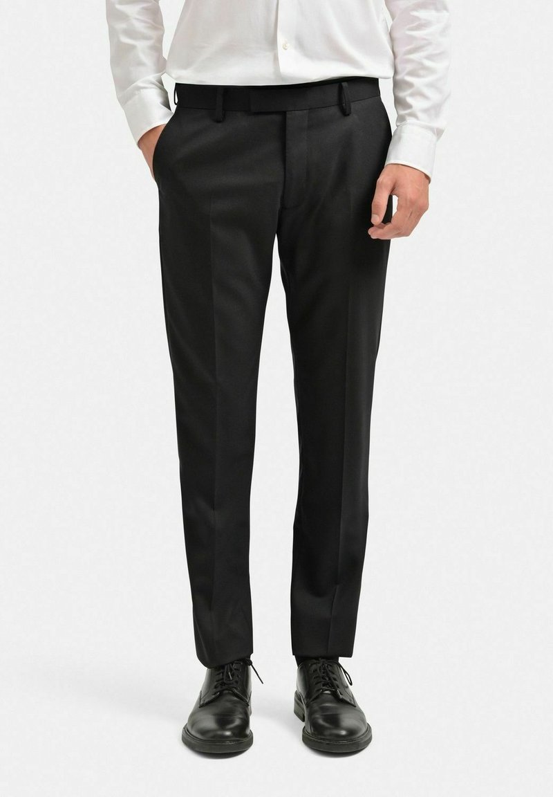 Svarta skräddarsydda byxor med rak bendesign, tillverkade av mjukt tyg, med bältesöglor och sidofickor, kombinerade med svarta läderskor.