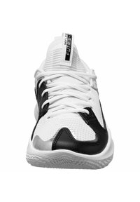 Scarpe da ginnastica bianche e nere con una tomaia in rete, motivi testurizzati e un accento argentato sulla suola. I lacci sono ben in evidenza.