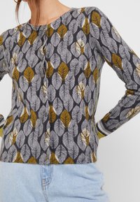 Cardigan mit einem Blattmuster in Grau, Grün und Gelb, langen Ärmeln, einer Knopfleiste und einem runden Ausschnitt. Weiches Textilmaterial.