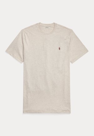 T-shirt manches courtes beige clair en coton doux, avec un col rond classique et un petit logo brodé sur la poitrine.