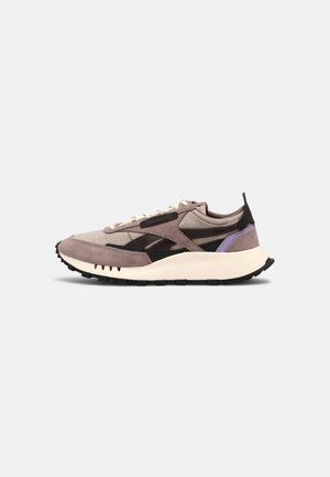 Low-top sneaker with beige and mauve suede, black accents, cream laces, and a chunky white sole with black tread.