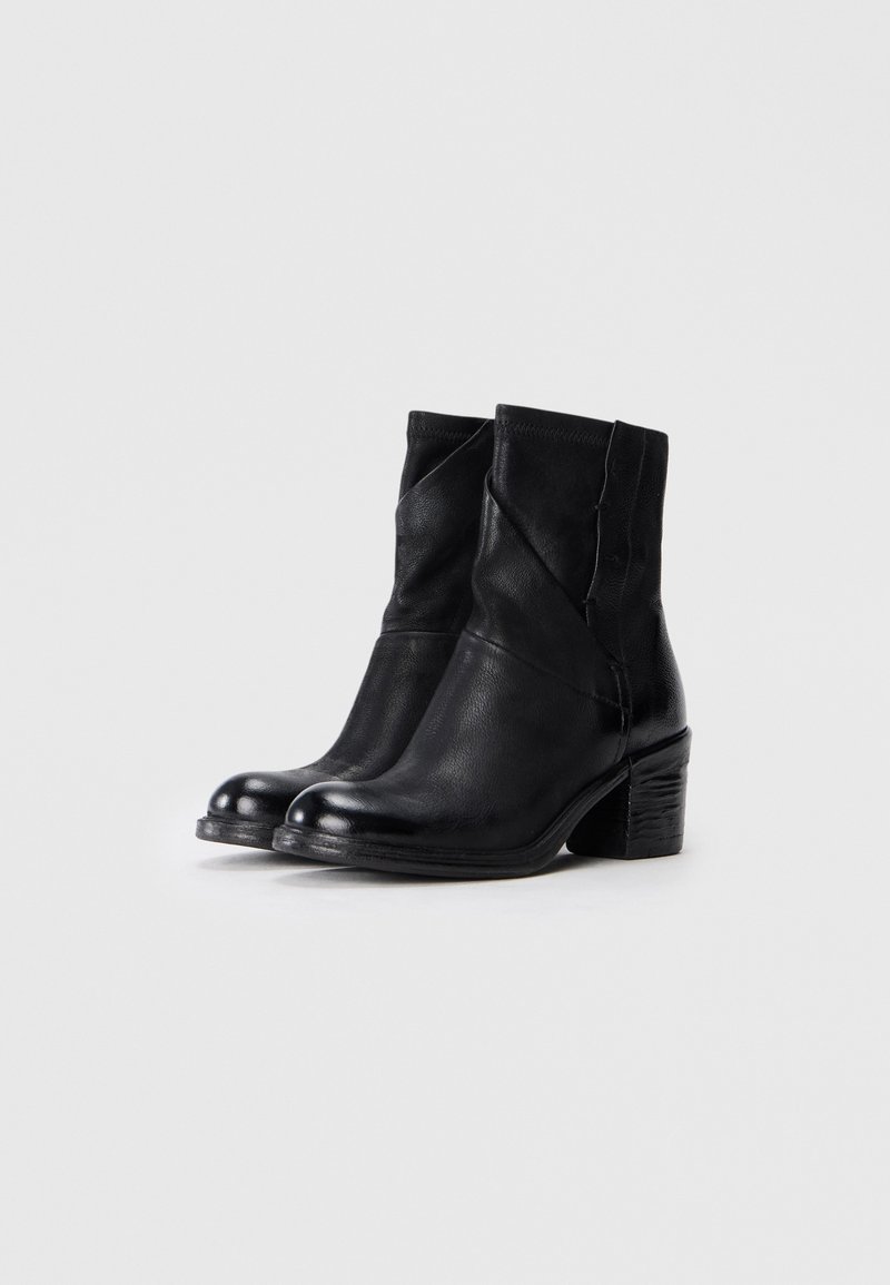 Bottines en cuir noir avec un talon carré texturé, présentant un design contemporain avec des détails angulaires sur les côtés.