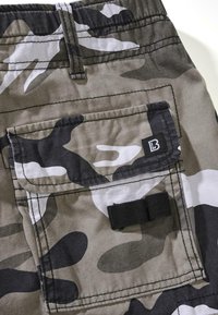 Kamuflasje cargo shorts med en blanding av grå, svart og hvite mønstre. Inkluderer en baklomme med en svart stropp og sømdetaljer.