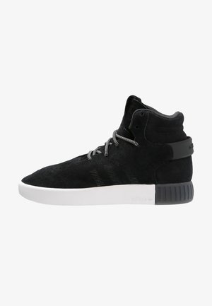 Black suede high-top sneaker with textured panels, white rubber sole, and contrasting laces. Features three stripe design on the side.