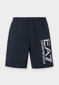 Tmavomodré bavlnené šortky s elastickým pásom a sťahovacou šnúrkou. Na ľavej strane je potlačené biele logo a textový dizajn.