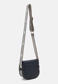 Granatowa torebka na ramię z gładkiego materiału z klapką, ozdobiona paskiem z wzorem i napisem "VALENTINO", który podkreśla design.