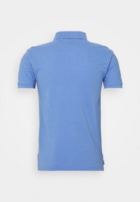 Polo bleu clair à manches courtes vu de dos avec un col côtelé et un ourlet droit.