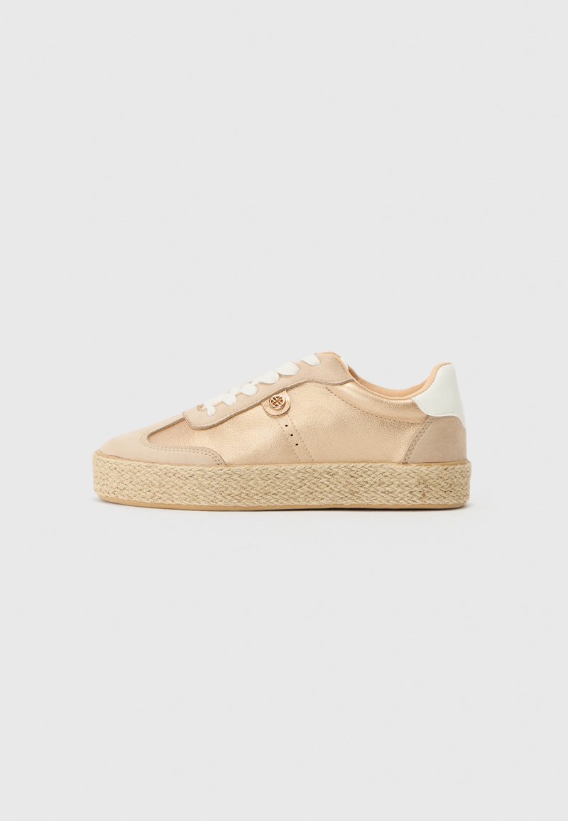 Beige sneakers med glatt materiale, hvite detaljer og en vevd jute plattformsåle. Har rund logo-detalj på siden og snøring.