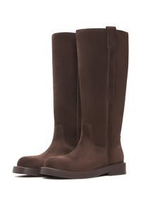 Botas altas de ante marrón con una textura suave, punta redonda y una suela plana y resistente. Cuentan con una aberturita lateral para facilitar su uso.