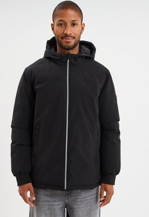 Giacca nera con cappuccio, chiusura frontale a zip, tasche laterali, polsini elastici e una texture liscia e opaca. Il design è semplice e funzionale.
