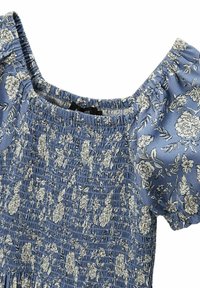 Robe florale bleue avec corsage smocké et manches bouffantes. Présente des motifs floraux blancs sur un tissu texturé, offrant un ajustement doux et élastique.