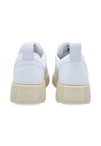 White leather sneakers with a textured off-white sole, featuring a rear pull tab and a smooth finish. Minimalist design with no visible patterns.