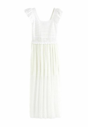 Robe maxi blanche sans manches avec corsage en dentelle, bretelles à volants et jupe plissée avec des détails subtils de motifs.