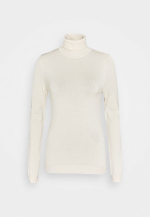Maglione a collo alto crema con maniche lunghe, texture a costine e design aderente. Il materiale sembra morbido e leggero.