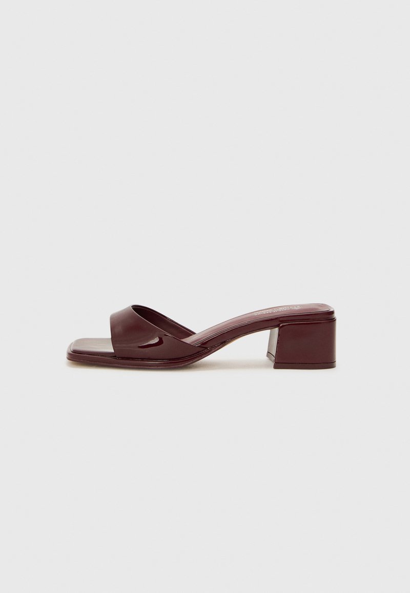 Burgundy, glossy heeled sandals with a wide strap, square toe, and block heel design. Smooth texture, minimalistic shape.