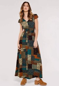 Robe maxi avec un design en patchwork aux multiples couleurs : teal, marron, crème et noir. Manches courtes et détail de taille nouée.
