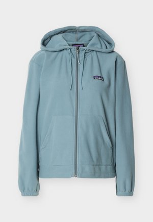 Gaiši zils vilnas džemperis ar rāvējslēdzēju, priekšējām kabatām, kapuci ar auklu, elastīgiem manšetēm un nelielu Patagonia logotipu kreisajā krūtīs.