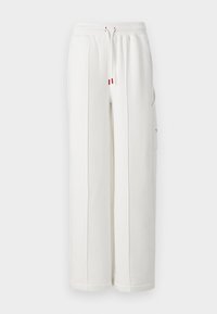 Pantalones de chándal blancos de algodón con cintura elástica, cordón, bolsillos laterales y costuras verticales. Diseño casual y de pierna ancha con un mínimo de marca.