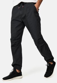 Pantalones cargo negros, ligeros y ajustados con puños elásticos, cintura con cordón, bolsillos laterales y detalles de costura notables.