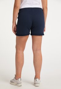 Marineblauwe katoenen shorts met omgerolde zomen, voorzien van een elastische tailleband. Draag ze met sneakers met metalen accenten voor een casual look.
