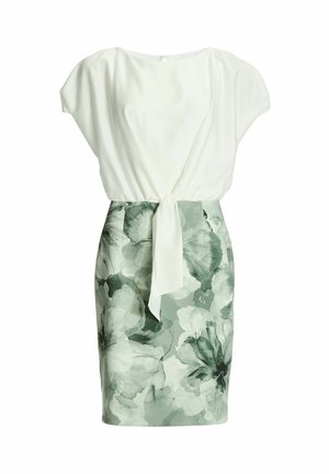 Hvid top med kapærmer, kombineret med et blomstergrønt skørt med bindebånd i taljen. Blødt stof med abstrakt blomstermønster.